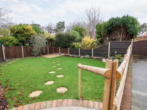 a garden with a fence and a grass yard at The Hollies in Prestatyn