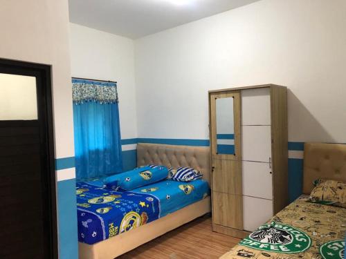 a bedroom with a bed and a dresser in it at PENGINAPAN BANYU BIRUKu in Kota-anyar