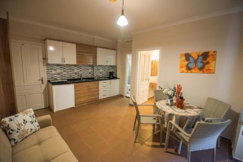 a living room with a table and a kitchen at Narcis Apart Hotel in Alanya