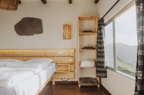 een slaapkamer met een bed en een raam bij Strela Mountain Lodge in Tarrafal