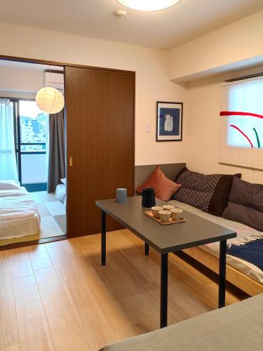 a living room with a table and a couch at ASAKUSAーHANAKAWADO in Tokyo