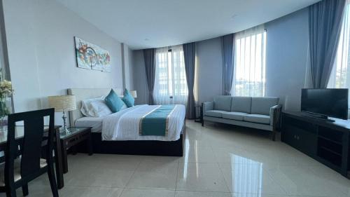 una camera con letto, divano e TV di Centerpoint Boutique Hotel a Vientiane