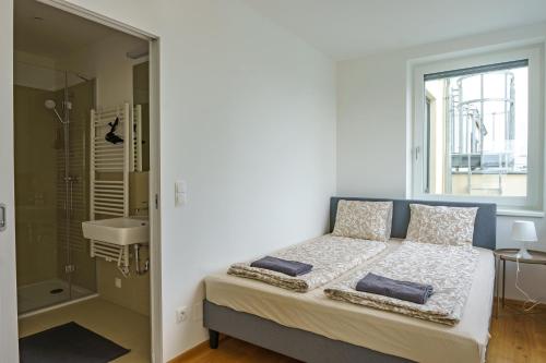 a bedroom with a bed and a shower and a window at Central Living Apartments - Belvedere in Vienna