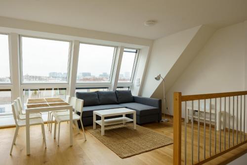 ウィーンにあるCentral Living Apartments - Belvedereのリビングルーム(青いソファ、テーブル付)