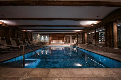 a swimming pool in a house with a large room at Hotel Tyrol in Selva di Val Gardena