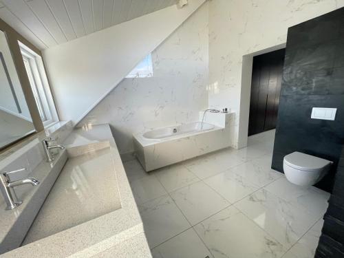 a white bathroom with a sink and a toilet at Big Villa centrally located in Reykjavik in Reykjavík