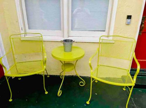 two chairs and a yellow table in front of a window at Front House 3 bedroom flat nice street, walk to BART, shops in Berkeley