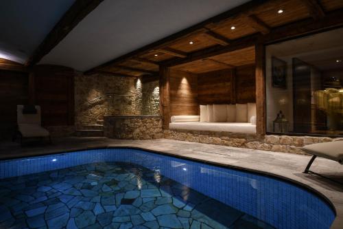 a swimming pool in a room with a bedroom at Hotel Tyrol in Selva di Val Gardena