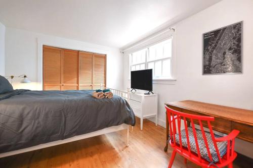 a bedroom with a bed and a desk and a television at Front House 3 bedroom flat nice street, walk to BART, shops in Berkeley