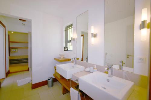 La salle de bains est pourvue de 2 lavabos et d'un miroir. dans l'établissement Villa Emerald, à Post of Flacq