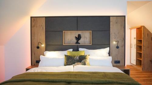 1 dormitorio con 1 cama grande y cabecero negro en KOASA HOF Bed and Breakfast en Oberhaag