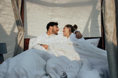 a man and a woman laying in bed at The Bubble Valley clarens in Clarens