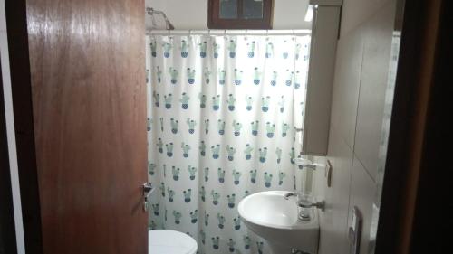 baño con lavabo y cortina de ducha en HOTEL FINCA AMANCAY en Villa Unión