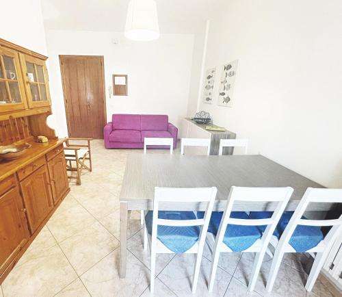 uma cozinha com mesa e cadeiras e um sofá roxo em Casa Vacanze da Silvy & Gio em Otranto