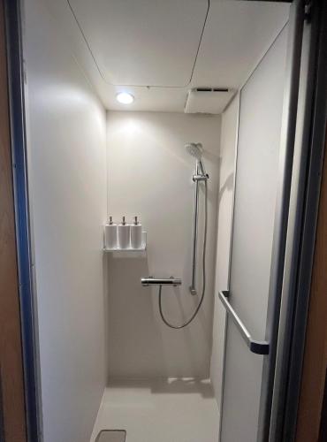 a bathroom with a shower and a toilet in it at AKUNOURA HUIS in Nagasaki