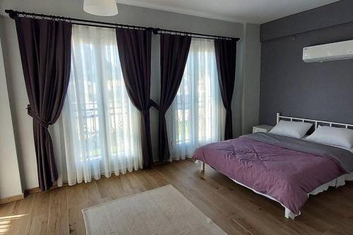 1 dormitorio con 1 cama y ventanas grandes en DalyanCentral 4BR Private Villa, en Dalyan