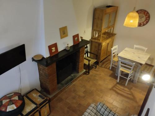 a living room with a fireplace and a table at La casa di sally in Pitigliano