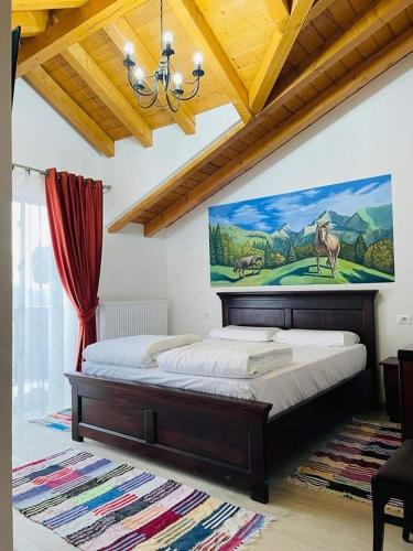 a bedroom with a bed with a painting on the wall at PIZZERIA RUSTICA cazare in Borşa