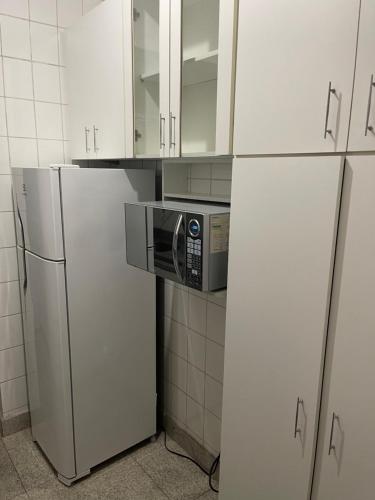 a kitchen with white cabinets and a microwave at apartamento completo in Contagem