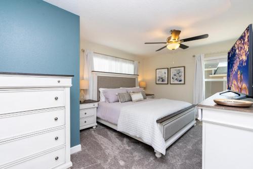 Schlafzimmer mit einem Bett und einem Deckenventilator in der Unterkunft Stunning 5 Bd w/ Pool Close to Disney 2905 in Kissimmee