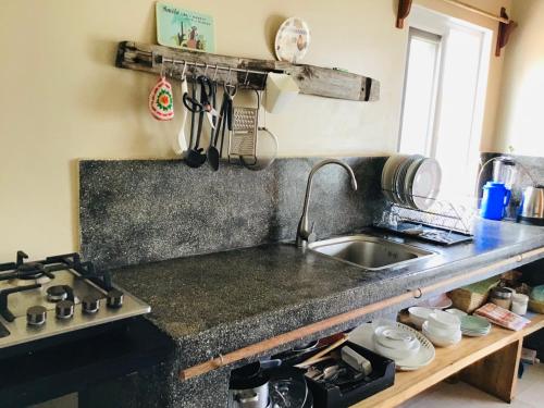um balcão de cozinha com um lavatório e um fogão em Nakupenda Malaika Flat em Pwani Mchangani