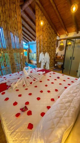 a bed with red hearts on it in a room at Chalé Arara super Luxo in Cunha