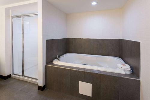 a bath tub in a bathroom with a shower at Wingate by Wyndham Vineland in Vineland