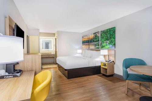 a hotel room with a bed and a table at Days Inn by Wyndham N Orlando/Casselberry in Orlando