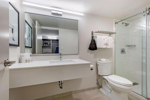 a bathroom with a sink and a toilet and a mirror at Best Western Premier Rockville Hotel & Suites in Rockville
