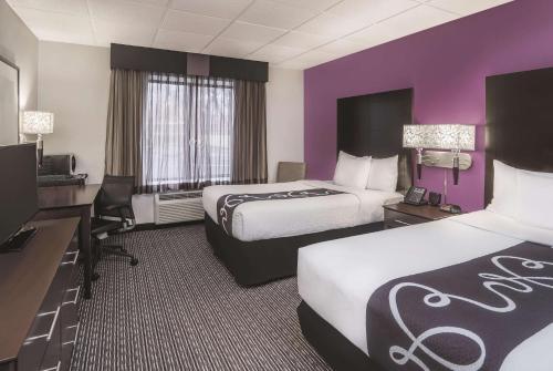 a hotel room with two beds and purple walls at La Quinta by Wyndham Las Vegas Summerlin Tech in Las Vegas