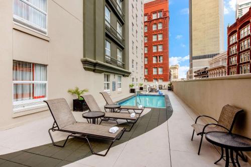 a balcony with chairs and a swimming pool on a building at La Quinta by Wyndham New Orleans Downtown in New Orleans