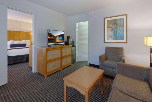 a hotel room with a bed and a living room at Travelodge by Wyndham Palm Springs in Palm Springs
