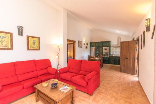 a living room with a red couch and a table at El Mirador de la Quinta in Vejer de la Frontera