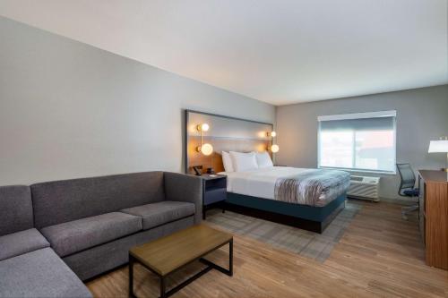 ein Hotelzimmer mit einem Bett und einem Sofa in der Unterkunft AmericInn by Wyndham San Angelo in San Angelo