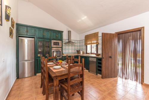 a kitchen with green cabinets and a table and chairs at El Mirador de la Quinta in Vejer de la Frontera