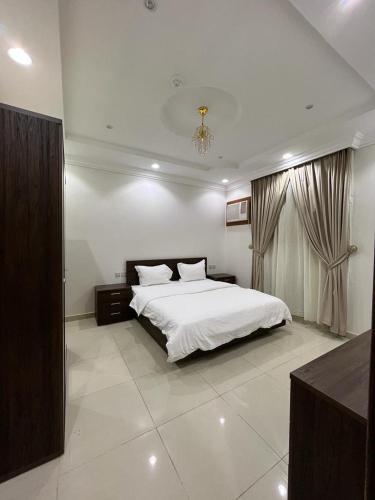 ein Schlafzimmer mit einem weißen Bett und einem Fenster in der Unterkunft غايا للشقق المخدومة in Tabuk