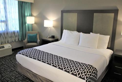a hotel room with a large bed and a chair at La Quinta Inn & Suites by Wyndham Indianapolis Downtown in Indianapolis