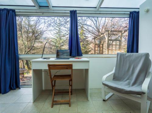 a desk and a chair in a room with a window at Horizons Verts Appartement Jasmin in Puivert