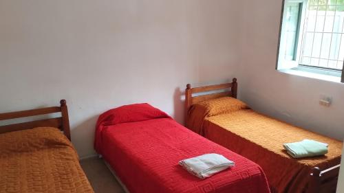 3 camas en una habitación con sábanas rojas en CASA NOSTRA en San Rafael