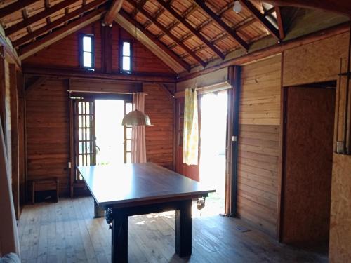 una mesa en el medio de una habitación con ventanas en Dunas do Moçambique, en Florianópolis