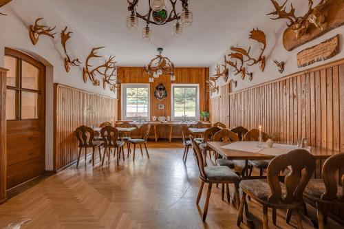a dining room with tables and chairs and a chandelier at Waldhotel & Restaurant Stieglitzenkrug in Feldberg