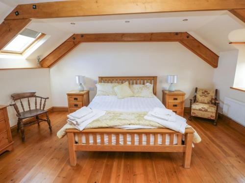 1 dormitorio con 1 cama y suelo de madera en Ty Crydd, en Kidwelly