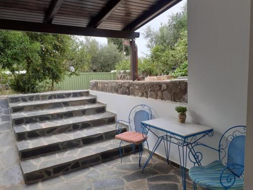 un patio con 2 sillas, una mesa y una mesa con sillas en A modern farmhouse with big garden en Trápeza