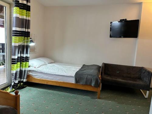 a small bedroom with a bed and a couch at Willa Marion in Karpacz
