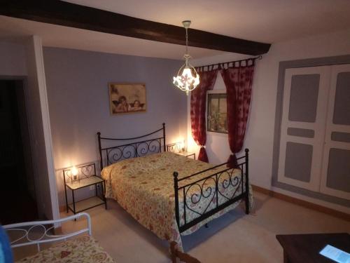 une chambre avec un lit et un lustre dans l'établissement La Mare aux 3 Diables, à Fresney-le-Vieux