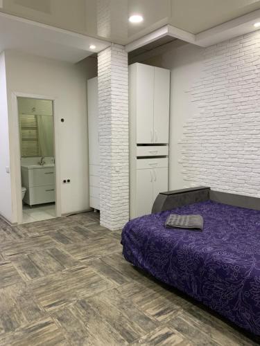 1 Schlafzimmer mit einem lila Bett und einem Badezimmer in der Unterkunft Квартира с отдельным входом с улицы in Chişinău