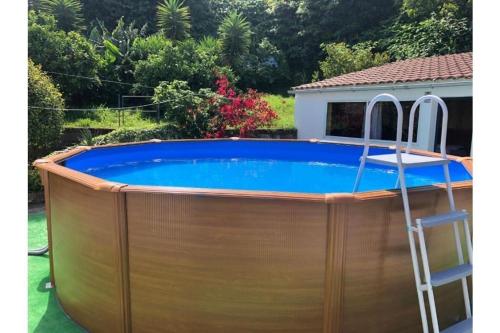 a large wooden pool with a ladder around it at Sunrise House Azores - jacuzzi in Senhora da Nazaré