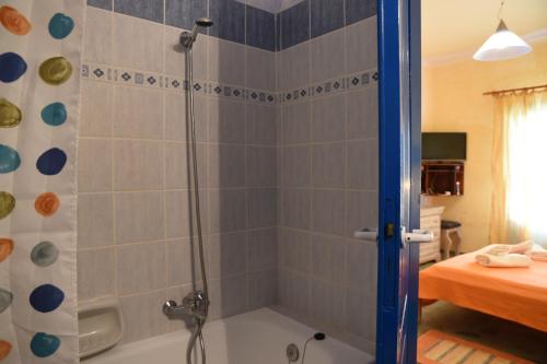 a bathroom with a shower with a bath tub at Elia Studios Amorgos near the sea in Aegiali