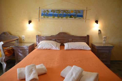 a bedroom with an orange bed with two towels on it at Elia Studios Amorgos near the sea in Aegiali