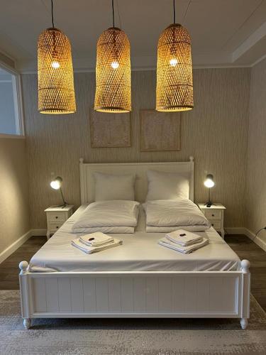 een slaapkamer met een wit bed en 2 handdoeken bij Ferienwohnung Watzmann-Stüberl 51 gehobene Ausstattung in Hamburg